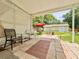 A covered patio features decorative brick flooring with seating and a view of the backyard shed under the shade of mature trees at 1537 Ne 22Nd St, Ocala, FL 34470