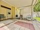 View of the covered patio with outdoor seating and decorative brick flooring adjacent to the yellow house exterior at 1537 Ne 22Nd St, Ocala, FL 34470