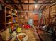 Interior of a shed with shelves, tools, paint cans, and other storage items, lit by a single lightbulb at 1537 Ne 22Nd St, Ocala, FL 34470