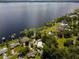 Expansive aerial view of a waterfront property with lush landscaping, private docks, and serene lake access at 15733 Tower View Dr, Clermont, FL 34711