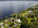 Aerial view showcasing the lakefront property with lush landscaping, boat docks, and a sparkling swimming pool at 15733 Tower View Dr, Clermont, FL 34711