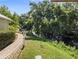 Lush backyard featuring mature trees, a winding brick path, and waterfront access, creating a serene outdoor retreat at 15733 Tower View Dr, Clermont, FL 34711