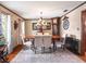 Cozy dining room with hardwood floors, a chandelier, an antique grandfather clock, and seating for six beneath a decorative mirror at 15733 Tower View Dr, Clermont, FL 34711