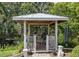 A lovely gazebo with a grill is set in a private yard with mature trees at 15733 Tower View Dr, Clermont, FL 34711