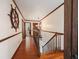 Hallway featuring hardwood floors, and access to a staircase with a nautical themed decorative steering wheel on the wall at 15733 Tower View Dr, Clermont, FL 34711