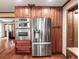 Gourmet kitchen equipped with stainless steel appliances, custom cabinets, a built-in oven, and a modern refrigerator at 15733 Tower View Dr, Clermont, FL 34711