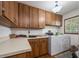 Functional laundry room with wood cabinets, countertop, and appliances for efficient chores at 15733 Tower View Dr, Clermont, FL 34711