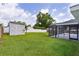 Wide backyard featuring a shed, a screened-in patio and well-maintained landscaping at 15828 Se 98Th Ter, Summerfield, FL 34491