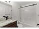 Bright bathroom featuring granite countertops, a modern faucet and white tiled shower/tub combo at 15828 Se 98Th Ter, Summerfield, FL 34491