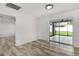 Bedroom with sliding glass door leading to a screened lanai and wood-look flooring at 15828 Se 98Th Ter, Summerfield, FL 34491
