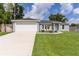 Inviting single-story home with a lush green lawn and a spacious two-car garage at 15828 Se 98Th Ter, Summerfield, FL 34491