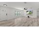 Spacious living room with wood-look floors, a modern ceiling fan, and ample natural light at 15828 Se 98Th Ter, Summerfield, FL 34491
