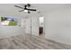 Bright main bedroom features wood-look floors, fan, television, and ensuite bathroom at 15828 Se 98Th Ter, Summerfield, FL 34491