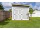 Exterior view of the yard shed offering extra storage with a nearby palm tree at 15828 Se 98Th Ter, Summerfield, FL 34491