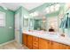 Bathroom with double sinks, wooden cabinets, and a large mirror at 16730 Se 78Th Lillywood Ct, The Villages, FL 32162