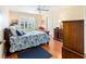 Comfortable bedroom with hardwood floors, window with shutters, and a bed with floral bedding at 16730 Se 78Th Lillywood Ct, The Villages, FL 32162