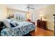 Bright bedroom features a window with shutters, neutral walls, and wood floors at 16730 Se 78Th Lillywood Ct, The Villages, FL 32162