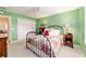 Cozy bedroom with green walls, ceiling fan, and comfortable furnishings at 16730 Se 78Th Lillywood Ct, The Villages, FL 32162