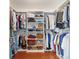 Walk-in closet with an organized layout including shelving, hanging rods, and wooden floors at 16730 Se 78Th Lillywood Ct, The Villages, FL 32162