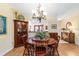 Charming dining room featuring wood floors, an elegant chandelier, and classic wood furniture at 16730 Se 78Th Lillywood Ct, The Villages, FL 32162