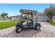 A personal blue golf cart parked on a paver driveway, ideal for community access at 16730 Se 78Th Lillywood Ct, The Villages, FL 32162