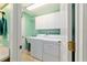 Well-lit laundry room with white washer and dryer, utility sink, and storage cabinets at 16730 Se 78Th Lillywood Ct, The Villages, FL 32162