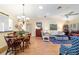 Open-concept living room and dining area with wood floors, chandelier, and neutral-colored walls at 16730 Se 78Th Lillywood Ct, The Villages, FL 32162
