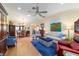 Bright living room with wood floors, fan, and furniture around a blue rug at 16730 Se 78Th Lillywood Ct, The Villages, FL 32162