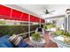 Comfortable screened patio with brick flooring, ceiling fan, and colorful wicker seating at 16730 Se 78Th Lillywood Ct, The Villages, FL 32162