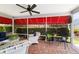 Relaxing screened patio with brick flooring, ceiling fan, and comfortable wicker seating at 16730 Se 78Th Lillywood Ct, The Villages, FL 32162