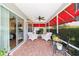 Relaxing screened in porch with brick pavers, ceiling fan, and outdoor seating area at 16730 Se 78Th Lillywood Ct, The Villages, FL 32162