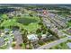 Aerial shot of a neighborhood with a community pool, golf course, pond, and surrounding green spaces at 1762 Meadowlark Ave, The Villages, FL 32162