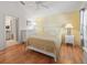 Sun-filled bedroom with a yellow accent wall, white dresser, and wood-look flooring at 1762 Meadowlark Ave, The Villages, FL 32162