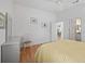 Bright bedroom featuring light wood floors, ceiling fan, and adjacent bathroom and walk-in closet at 1762 Meadowlark Ave, The Villages, FL 32162