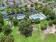 Aerial shot of community pool, clubhouse, putting green, and parking in lush, green surroundings at 1762 Meadowlark Ave, The Villages, FL 32162