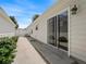 Exterior showcasing a sliding glass door to a patio, along a meticulously landscaped walkway at 1762 Meadowlark Ave, The Villages, FL 32162