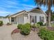 Charming single-story home with a well-manicured lawn, a two-car garage, and mature palm trees at 1762 Meadowlark Ave, The Villages, FL 32162