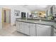 Bright kitchen features white cabinets and an eat-in bar overlooking the living spaces at 1762 Meadowlark Ave, The Villages, FL 32162