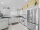 Bright kitchen featuring stainless steel appliances, white cabinets, and tile flooring at 1762 Meadowlark Ave, The Villages, FL 32162