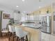 Modern kitchen showcasing white cabinets, stainless steel appliances, and stylish bar seating at 1762 Meadowlark Ave, The Villages, FL 32162