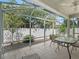 Relaxing screened patio with a table and chairs overlooking the manicured backyard at 1762 Meadowlark Ave, The Villages, FL 32162