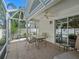 Screened patio features neutral tile, seating, and ceiling fan, perfect for outdoor living at 1762 Meadowlark Ave, The Villages, FL 32162