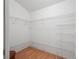 Walk-in closet with built-in white wire shelving and wood-look flooring at 1762 Meadowlark Ave, The Villages, FL 32162