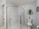 Clean bathroom featuring a glass-enclosed shower and a standard toilet with patterned tile flooring at 17860 Se 89Th Natchez Ave, The Villages, FL 32162