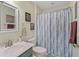 Bright bathroom with a marble countertop, and a shower with striped blue and purple curtain at 17860 Se 89Th Natchez Ave, The Villages, FL 32162