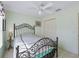 Cozy bedroom with a white ceiling fan, light green walls, and a unique, decorative metal headboard at 17860 Se 89Th Natchez Ave, The Villages, FL 32162