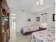 Bedroom featuring two beds with floral comforters, a cabinet, and tile flooring at 17860 Se 89Th Natchez Ave, The Villages, FL 32162