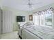 Bright bedroom with tile flooring, a modern ceiling fan, closet and window allowing natural light at 17860 Se 89Th Natchez Ave, The Villages, FL 32162