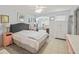 Comfortable bedroom with neutral tile floors, a large bed, and an connected bonus sitting area at 17860 Se 89Th Natchez Ave, The Villages, FL 32162