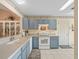 Bright kitchen featuring blue cabinets, white appliances, and ample counter space for cooking and preparation at 17860 Se 89Th Natchez Ave, The Villages, FL 32162
